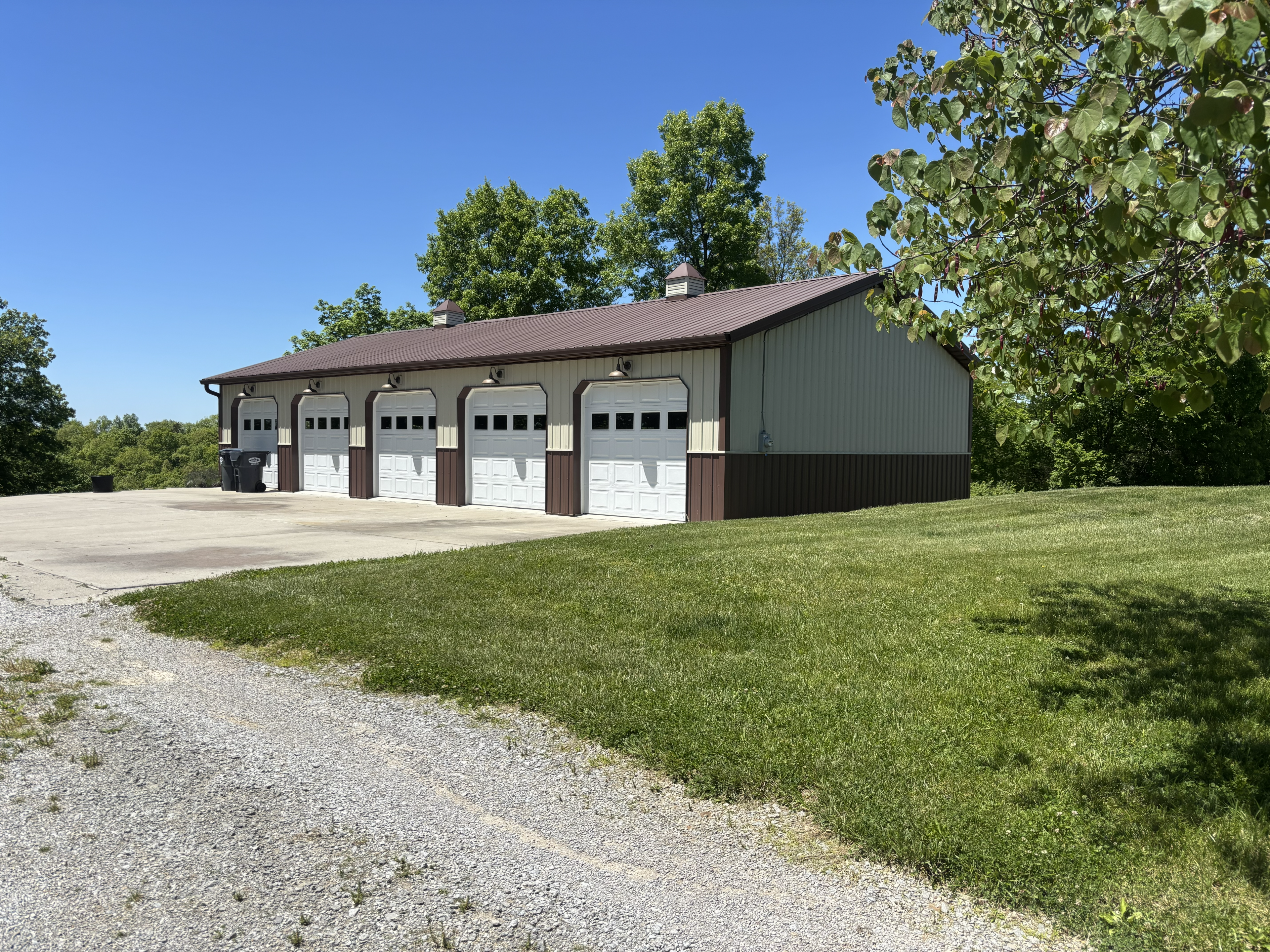 Five-bay metal garage building on grassy lot