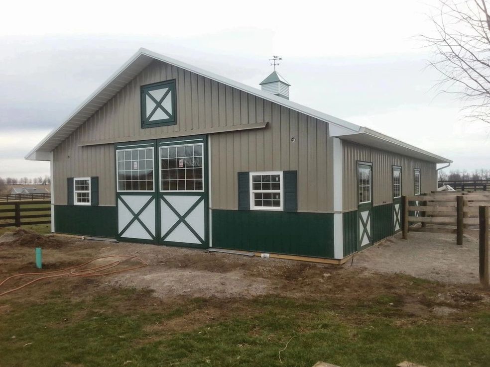 Modern green and beige horse barn exterior