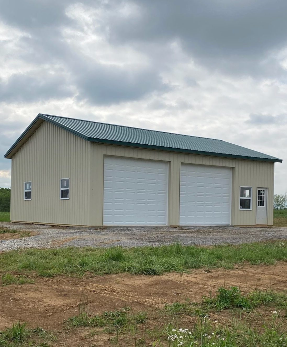 Beige metal garage with two overhead doors