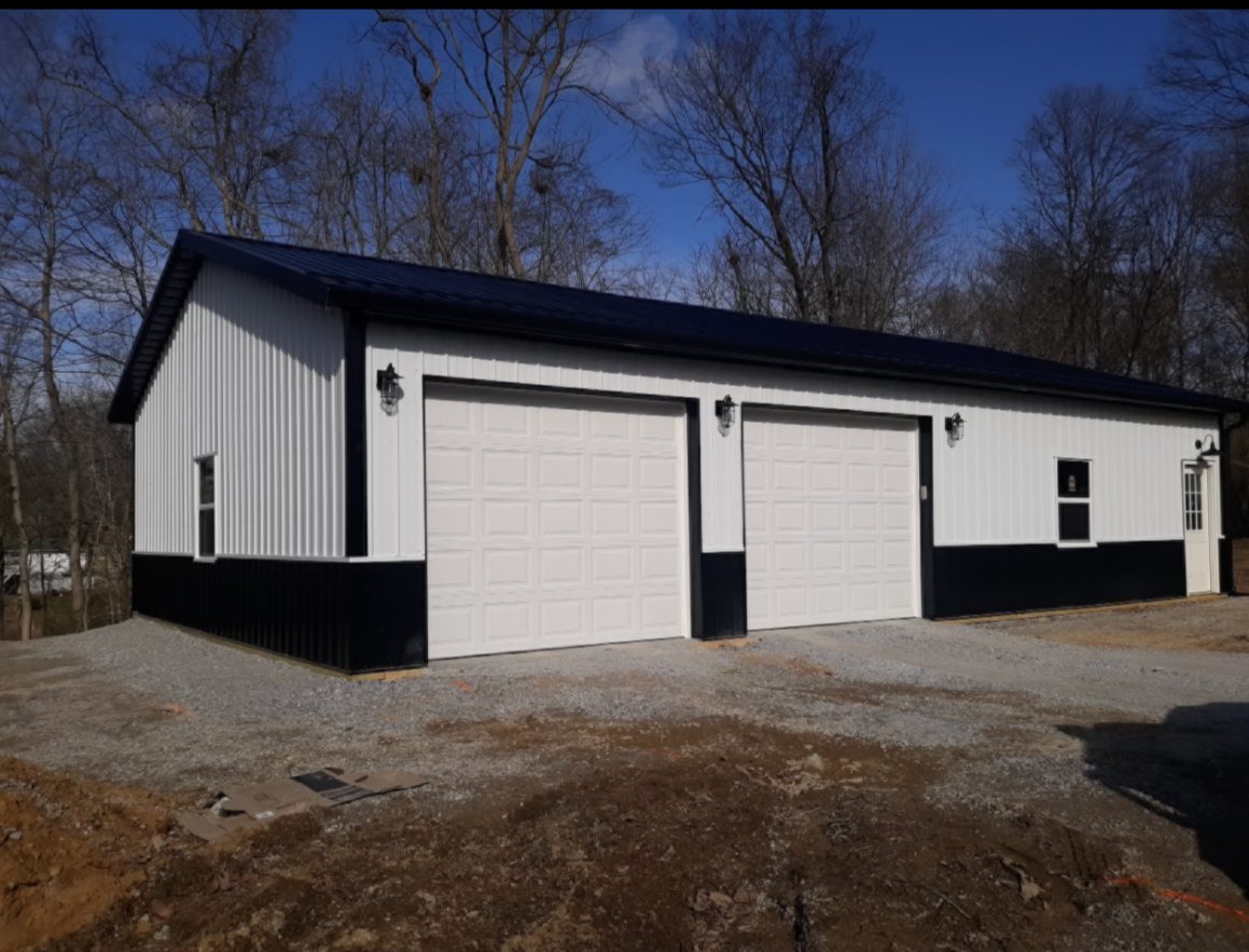 Metal three-bay garage with white doors