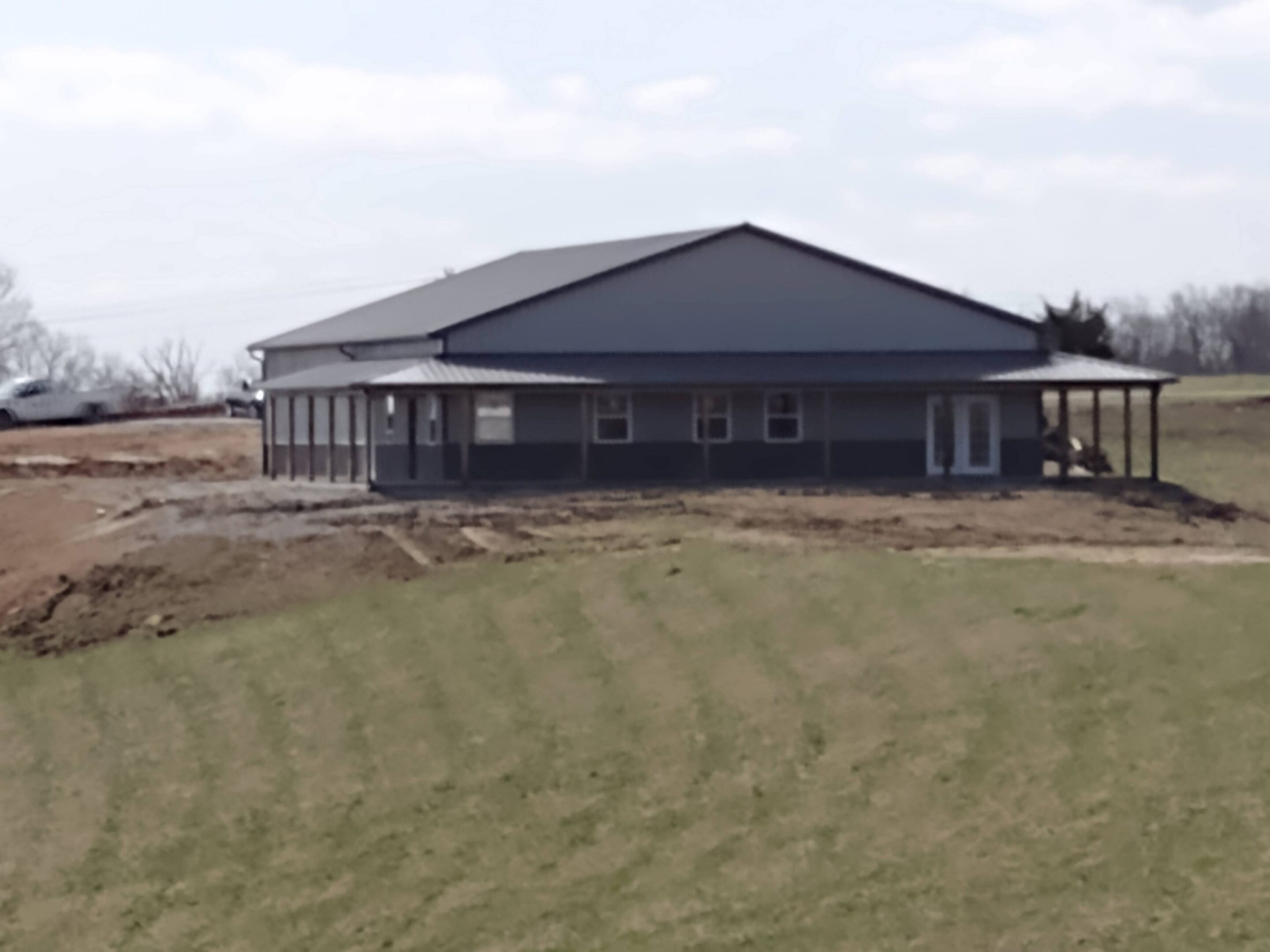 Large metal barn-style building on grassy field