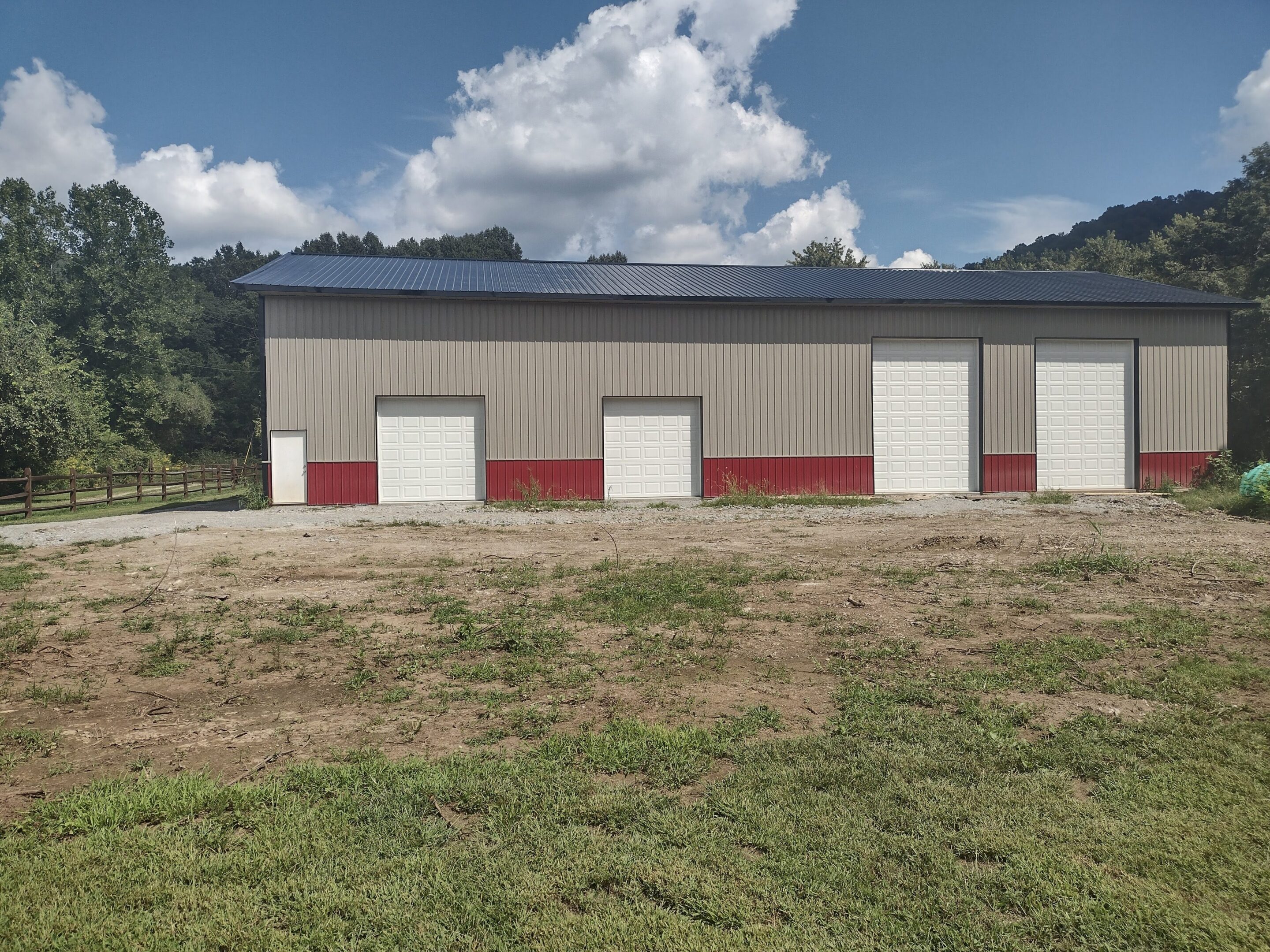 Beige metal building with four garage doors