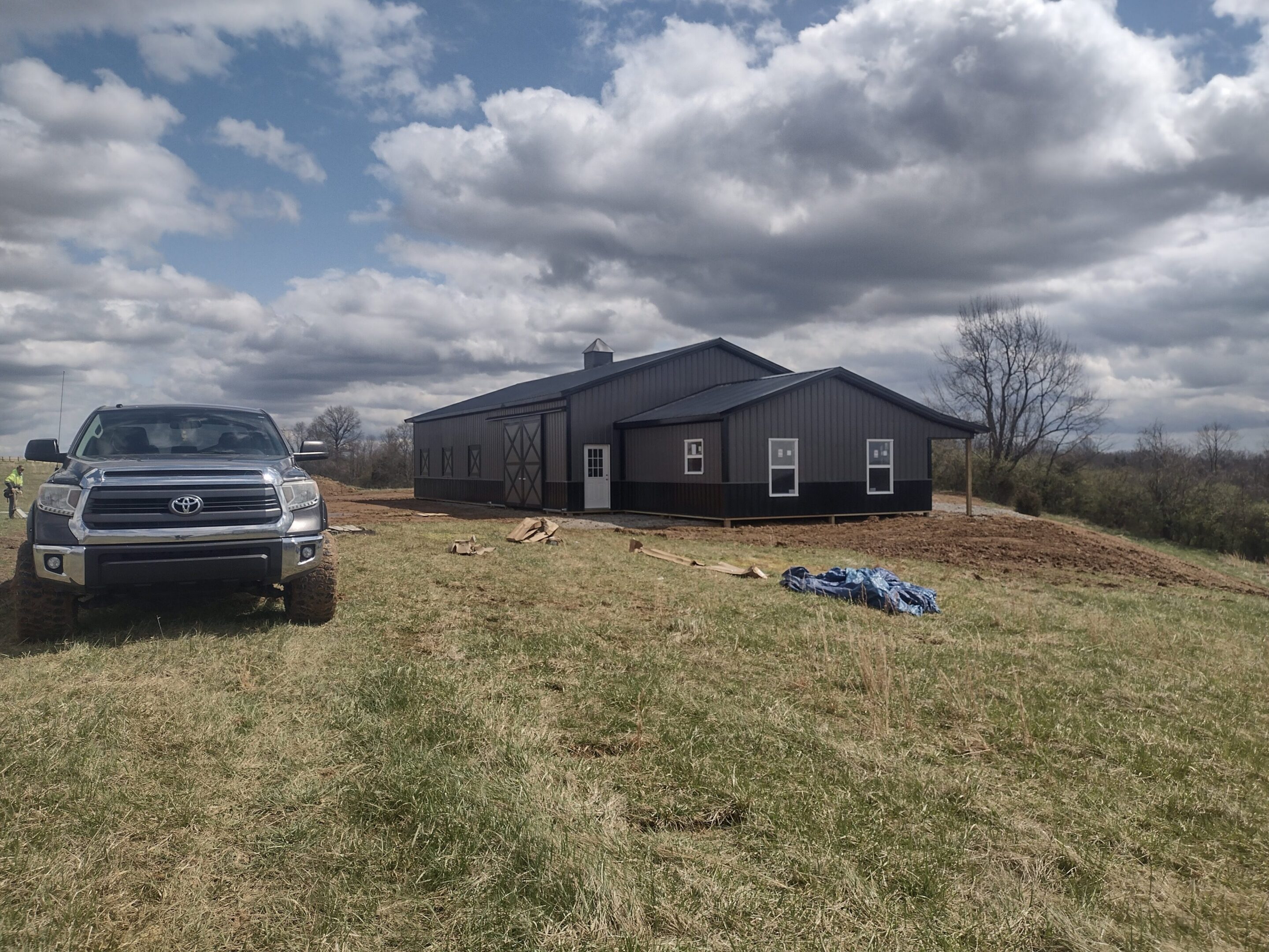 Rural gray metal barn with pickup truck