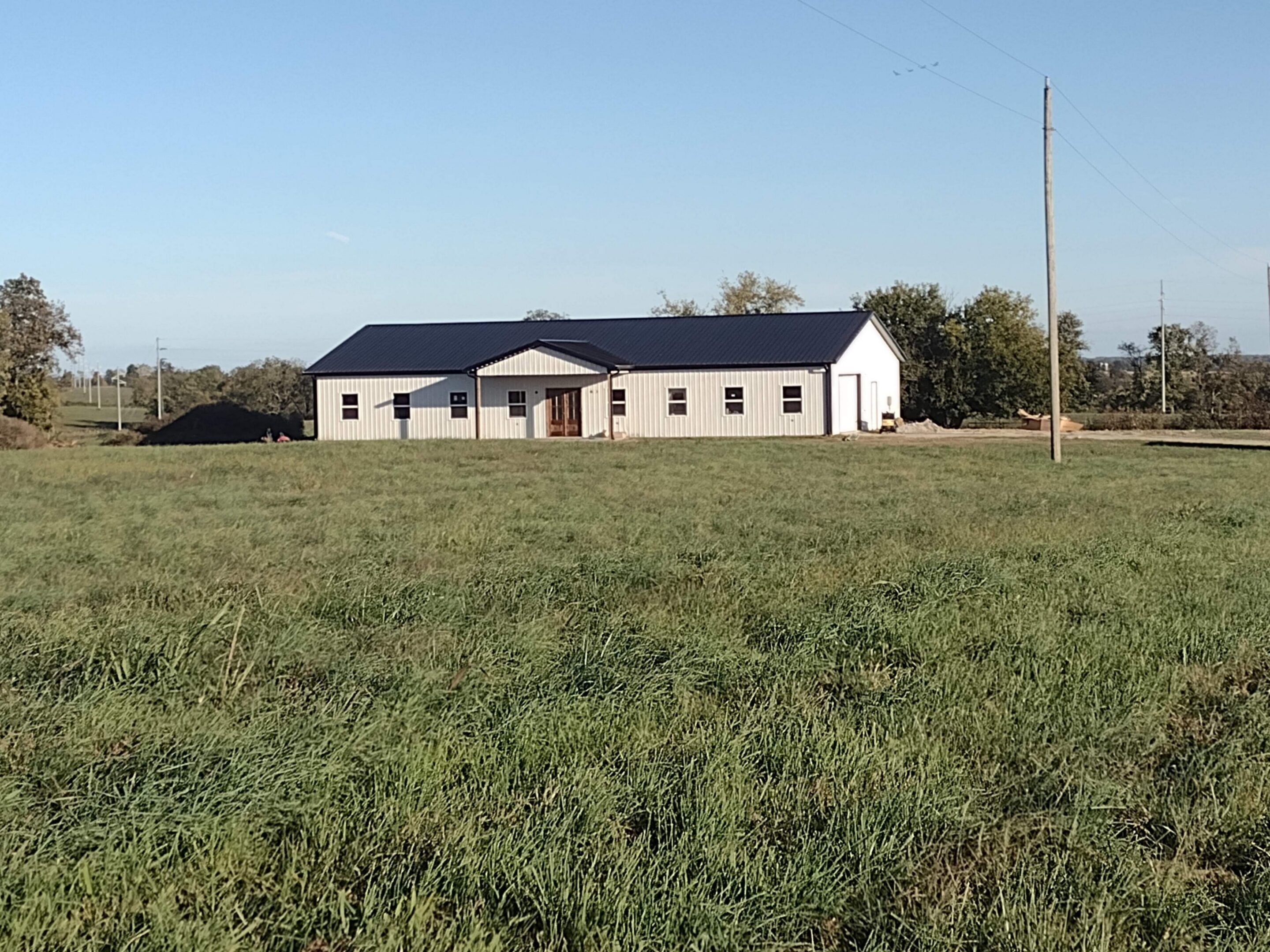 Rural white building with black roof