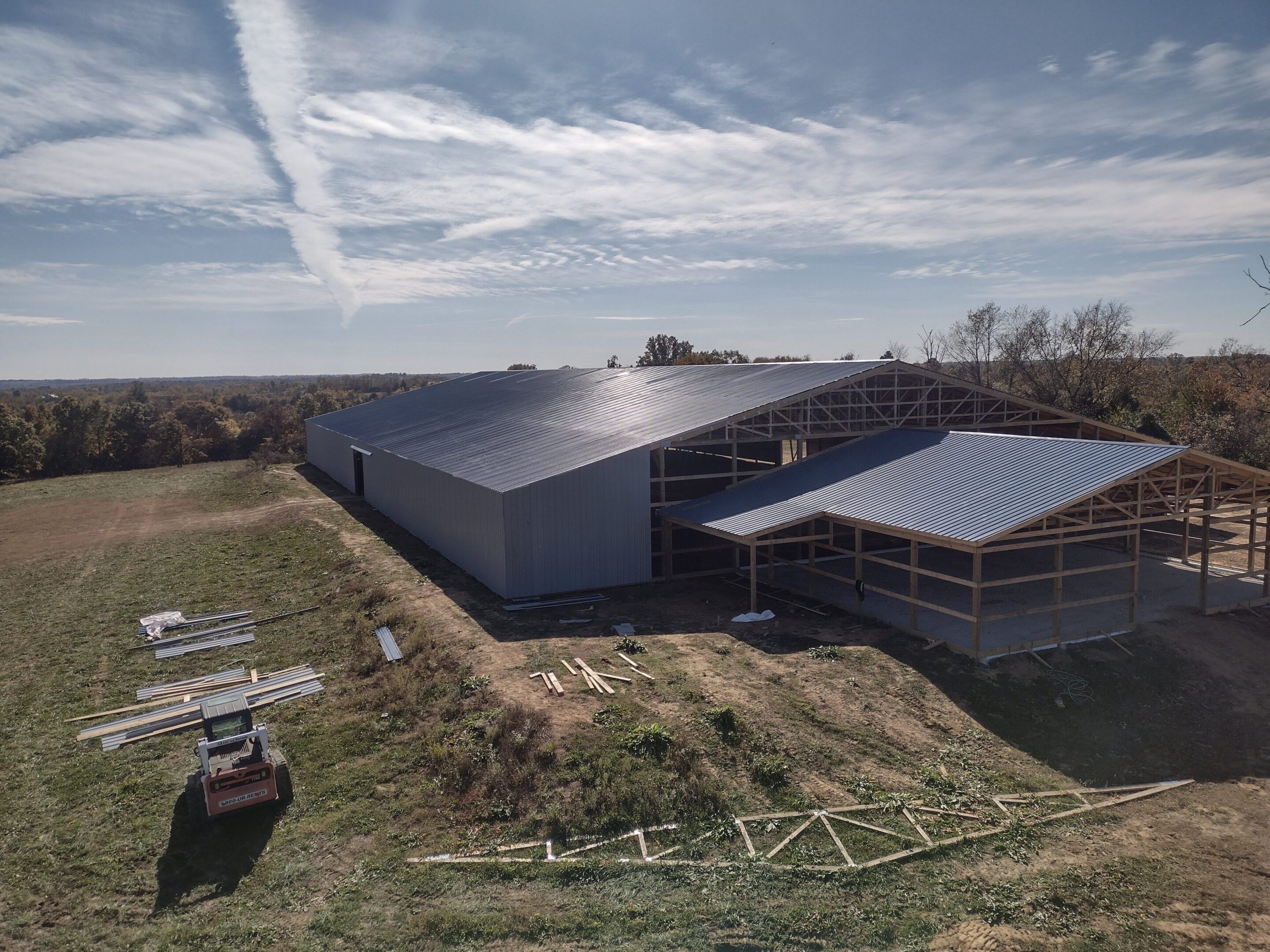 Large metal barn under construction in field