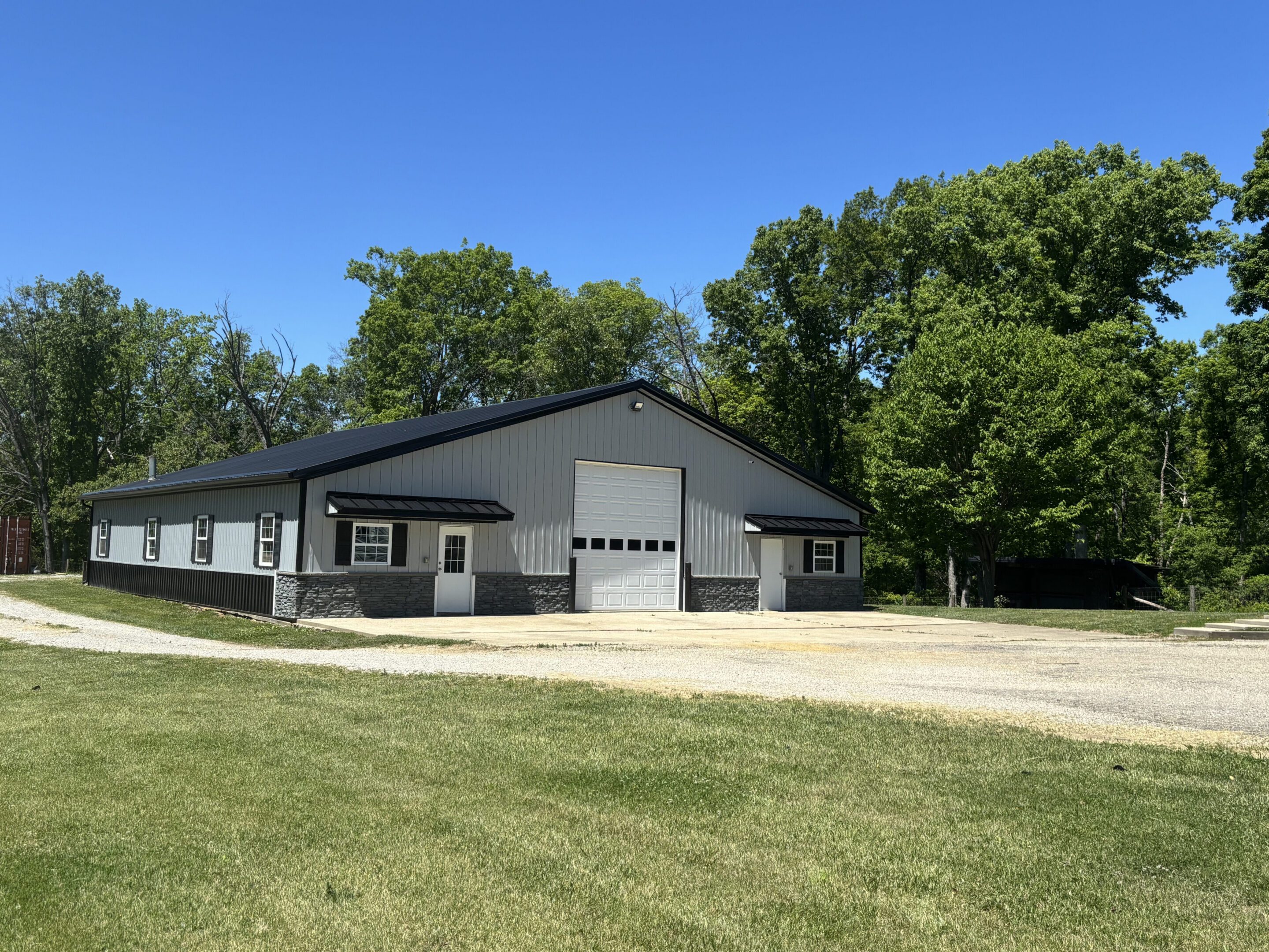 Light gray metal building with garage door